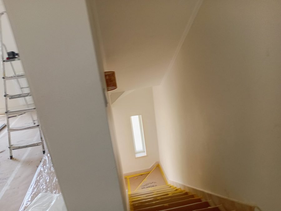 Stairwell with plastered walls and a stepladder
