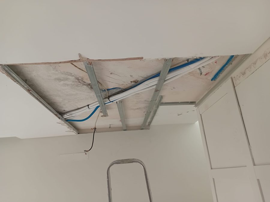 Teto aberto com a cablagem elétrica nova e a estrutura metálica à vista