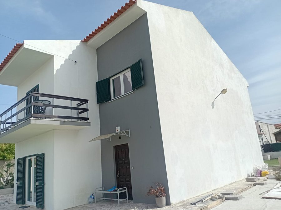 Side view of the house, with the balcony and the grey wall