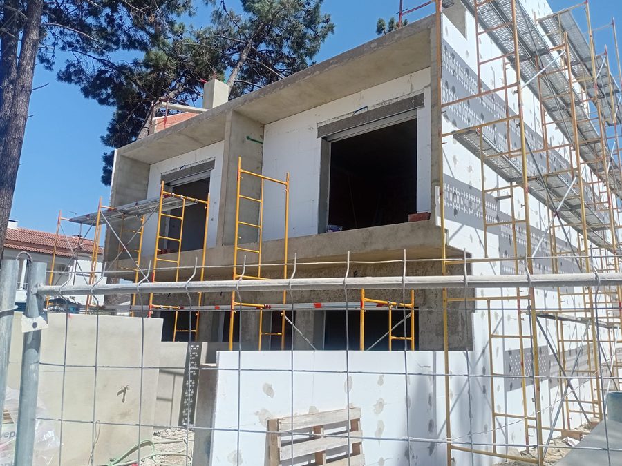 Andaimes montados à frente da fachada, com o isolamento a ser colocado
