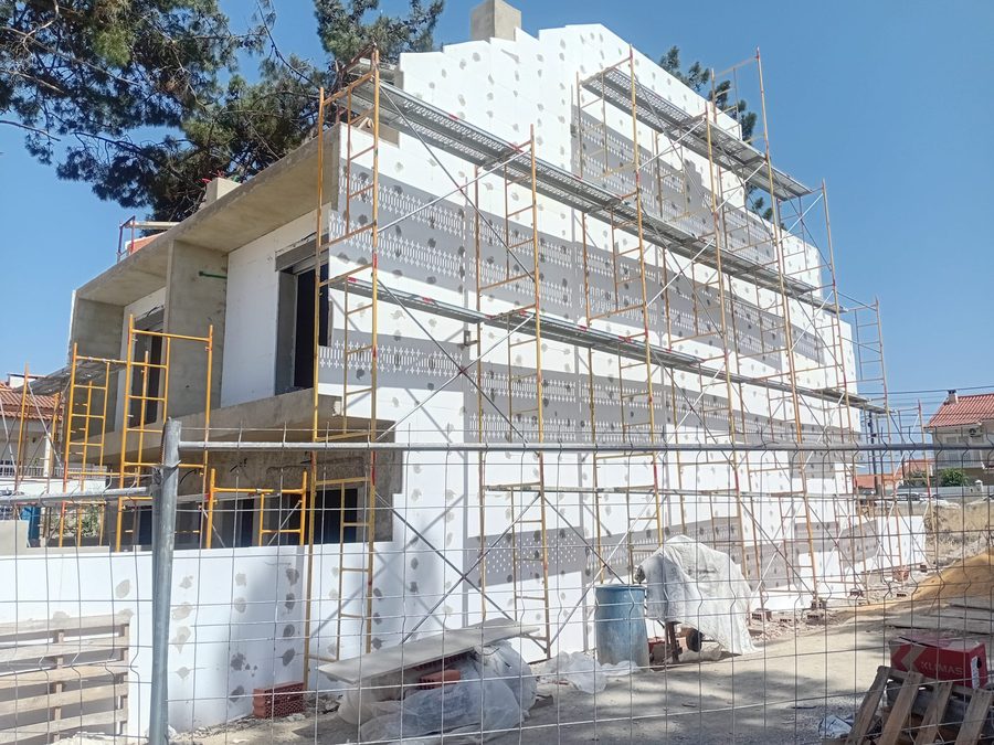 Fachada coberta de placas de isolamento térmico, com andaimes montados