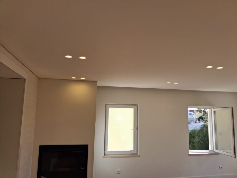 The same living room finished, with the fireplace, painted walls and ceiling spotlights