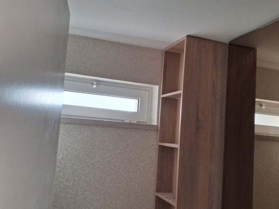 Finished bathroom with a wooden column and a white vanity top