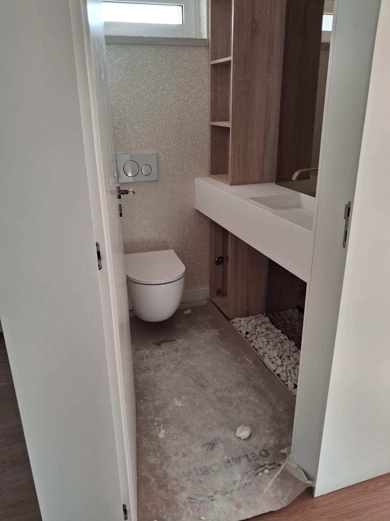 Bathroom during the works, with the floor unfinished and covered in dust