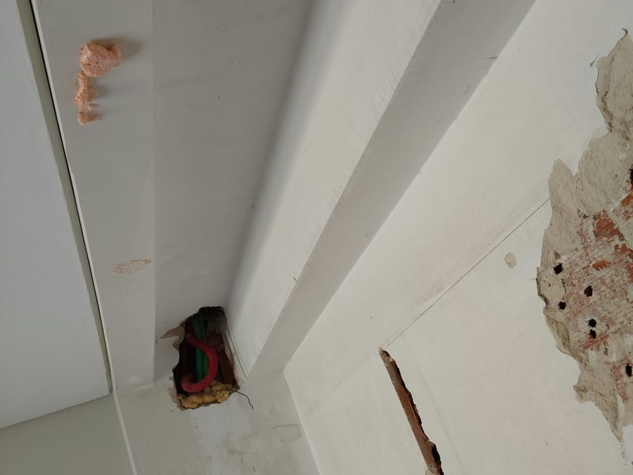 Corner with chases cut into the wall and exposed conduits